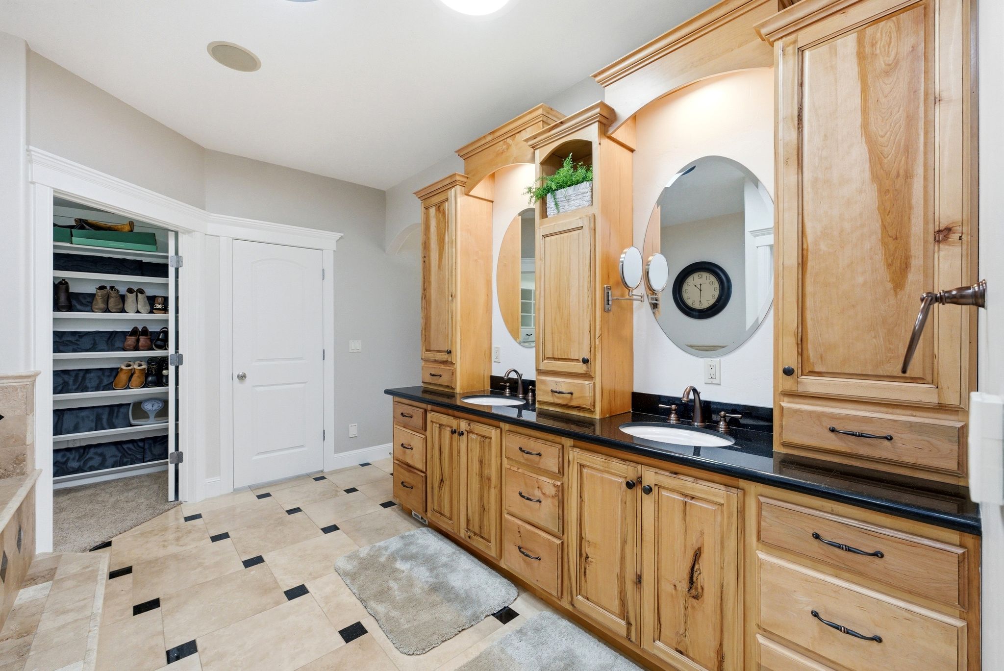 Full bath featuring double vanity, a spacious closet, and light tile patterned floors