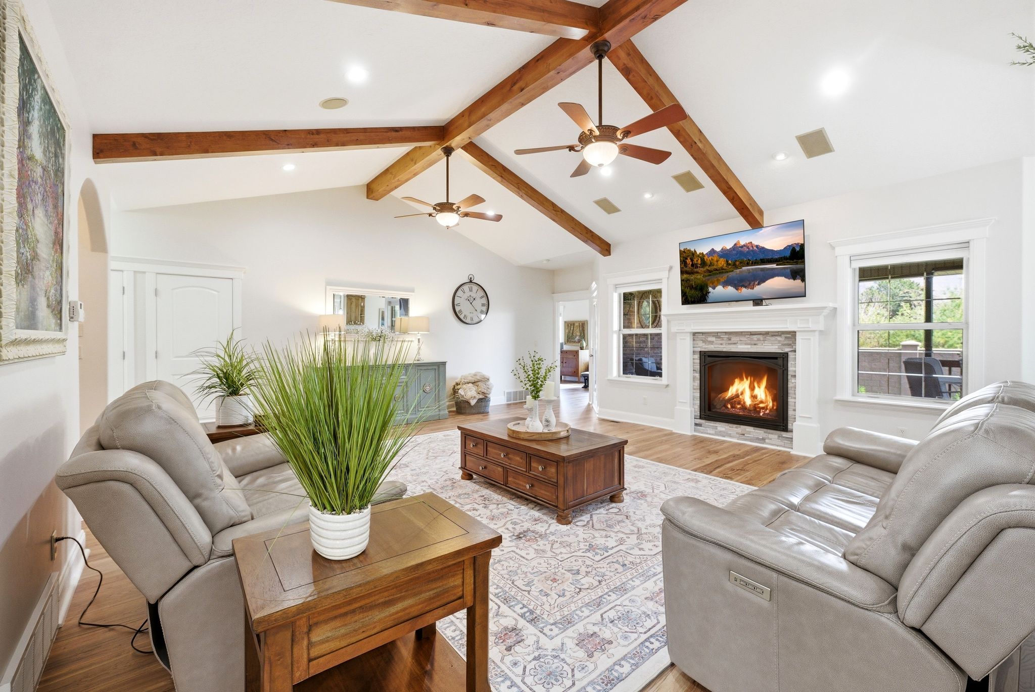 Living area with a stone fireplace, light wood-style floors, recessed lighting, and a ceiling fan
