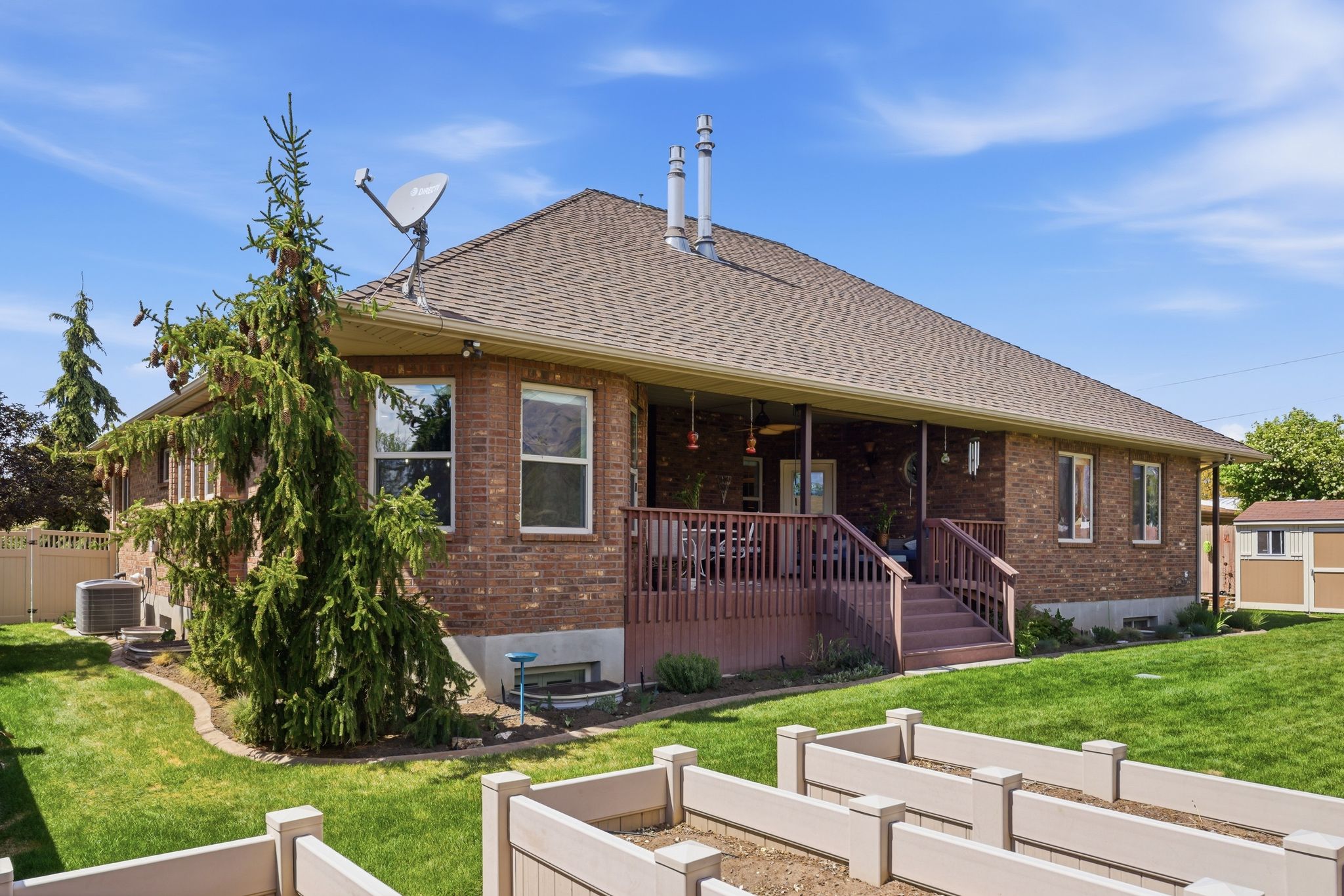 View of front of property with brick siding, a shingled roof, and a ceiling fan
