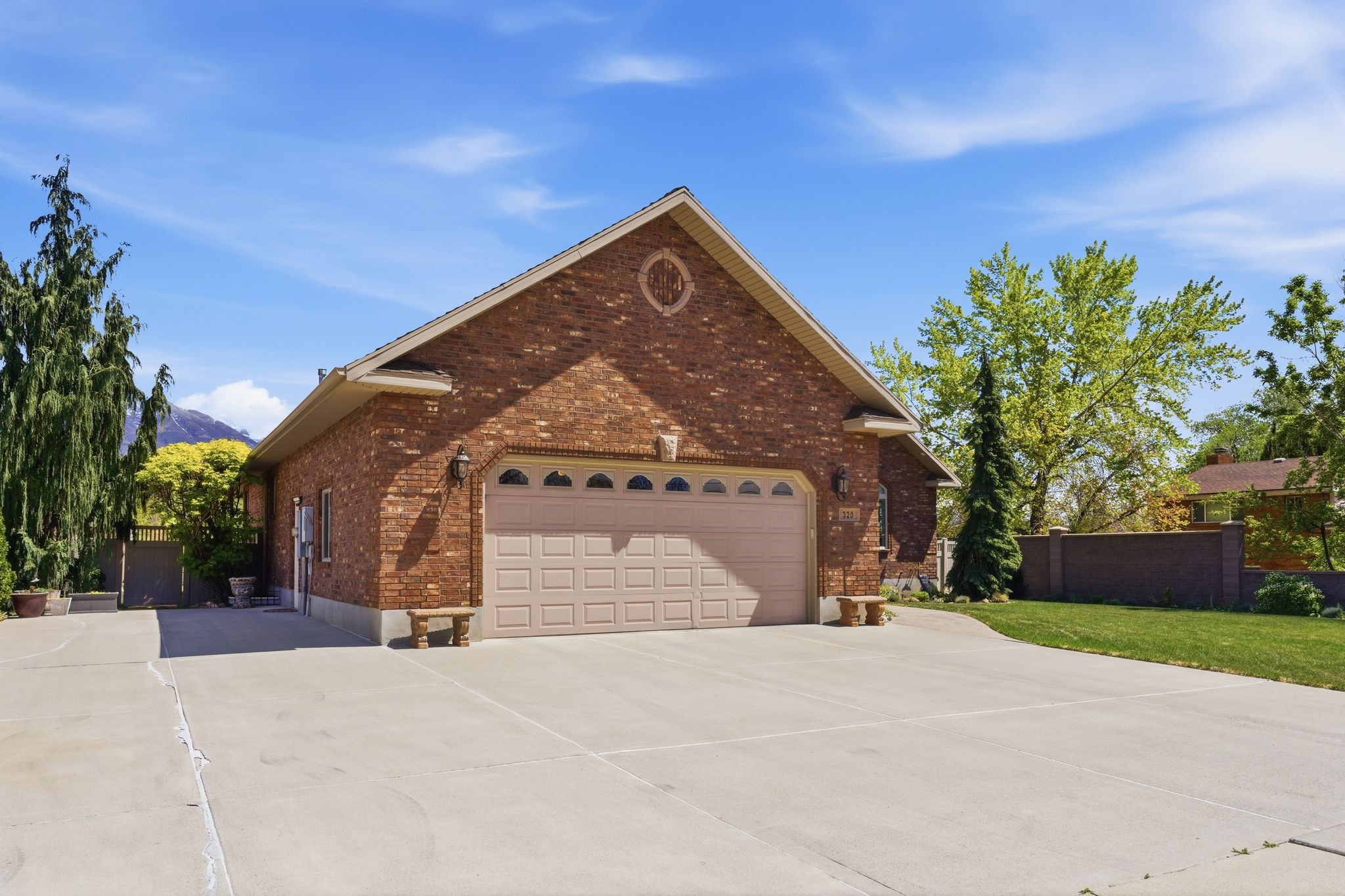 View of front of home featuring driveway, brick siding, and a garage
