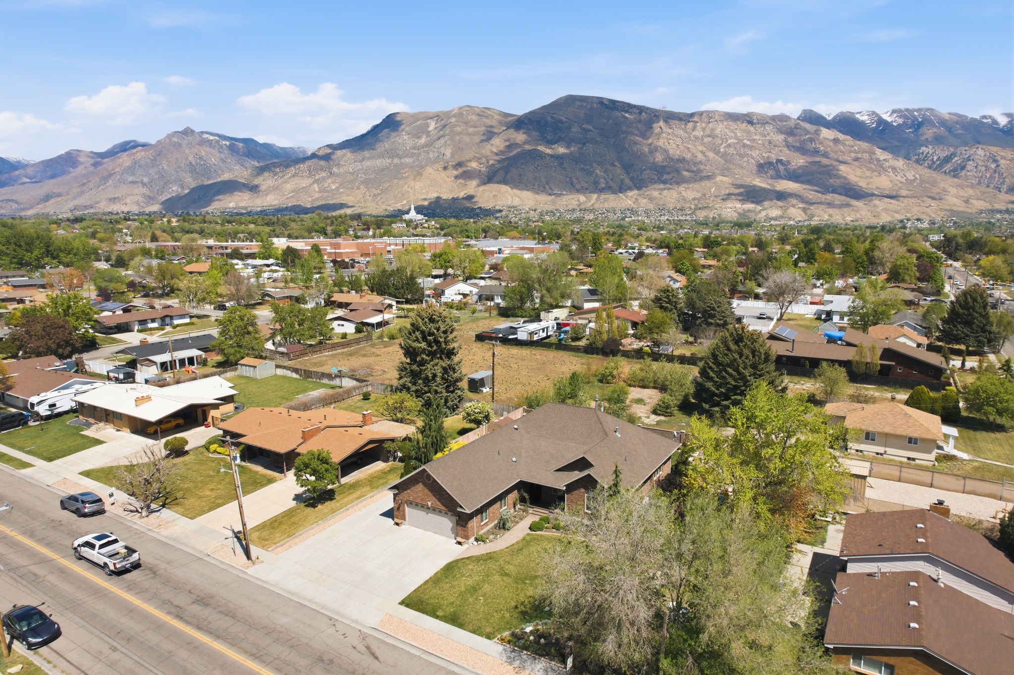 Aerial view of property and surrounding area featuring nearby suburban area and mountains