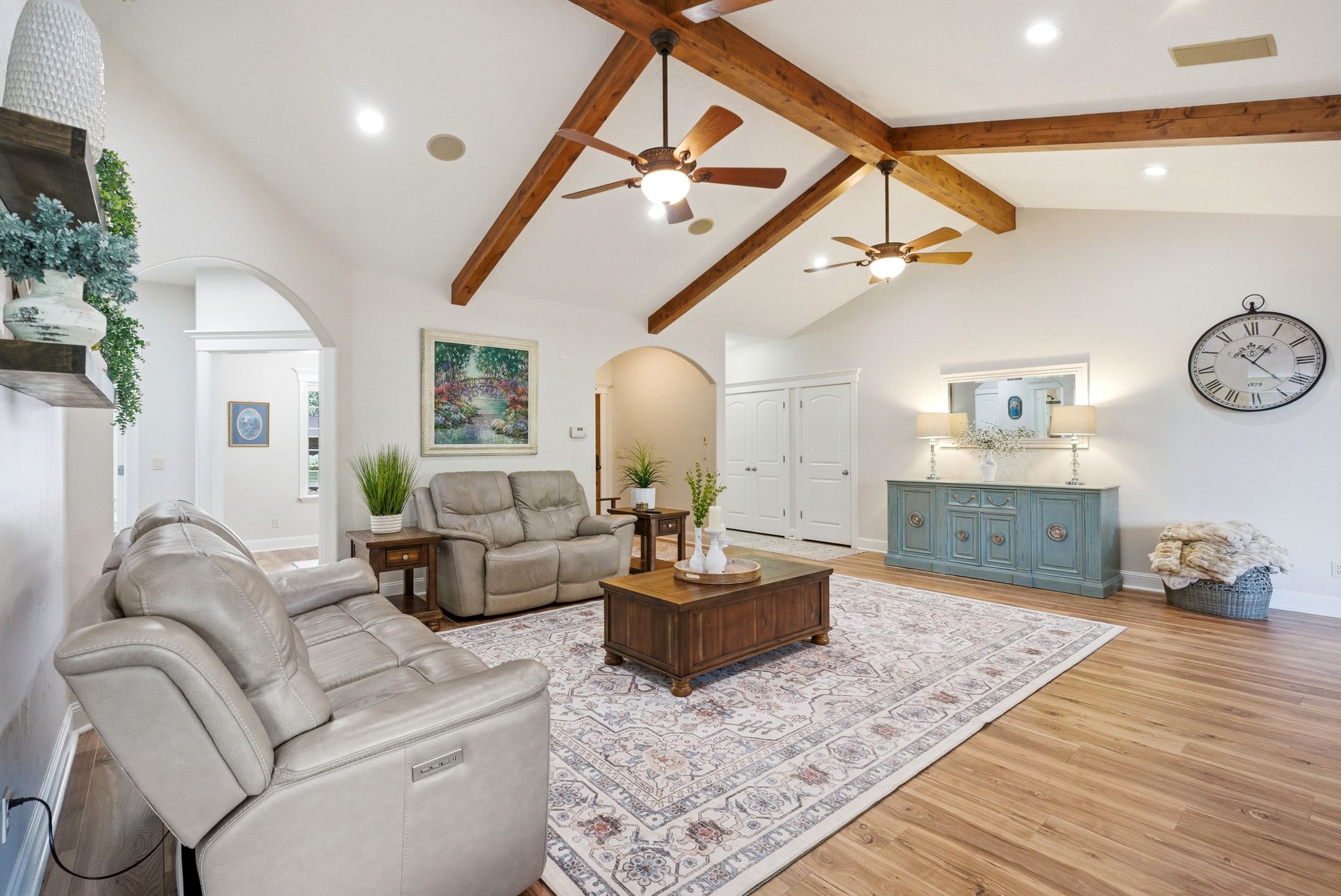 Living area with arched walkways, light wood-style flooring, recessed lighting, and ceiling fan
