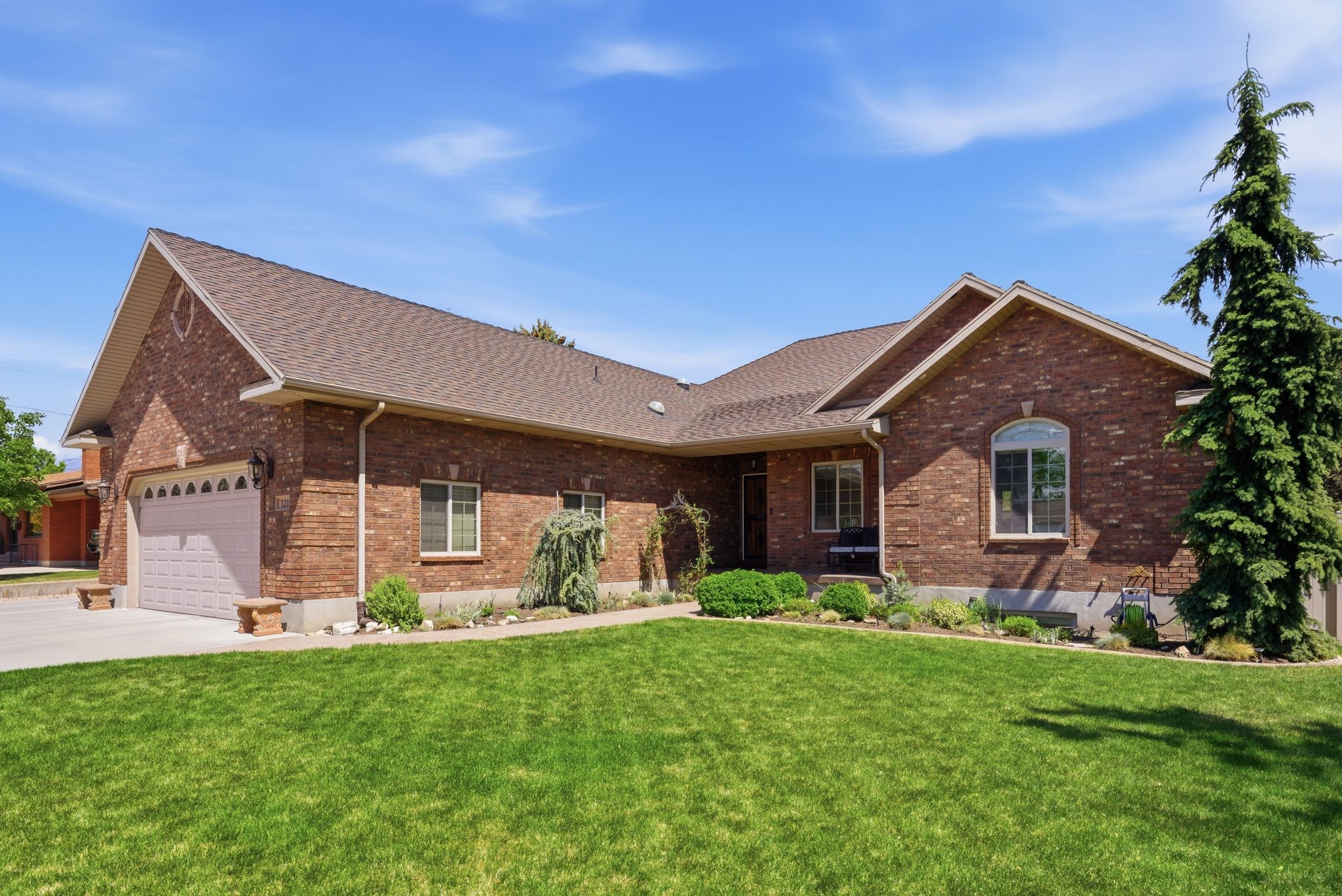 Ranch-style house with brick siding, a front yard, an attached garage, and a shingled roof