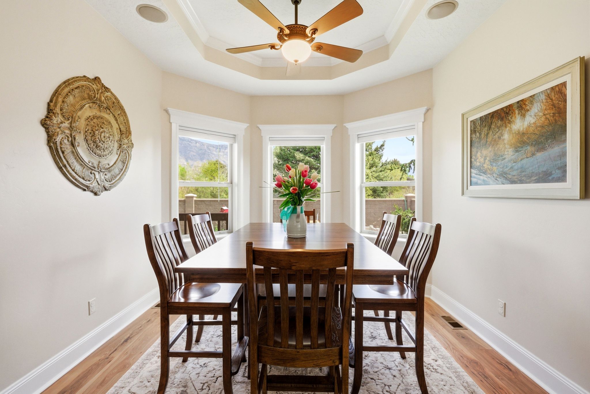 Dining room with light wood-style floors, plenty of natural light, ceiling fan, and ornamental molding