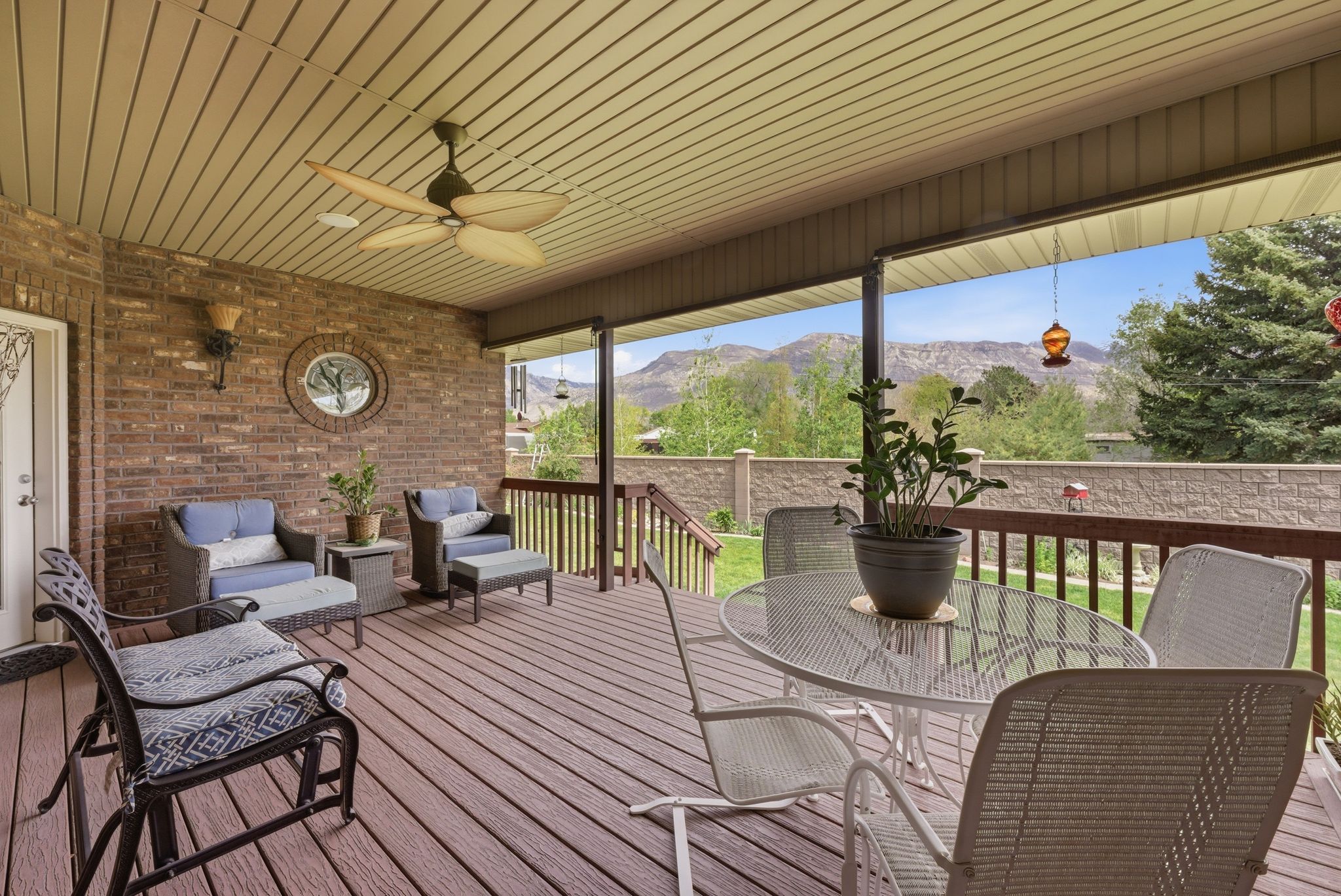Deck with a ceiling fan, an outdoor living / dining area, and a mountain view