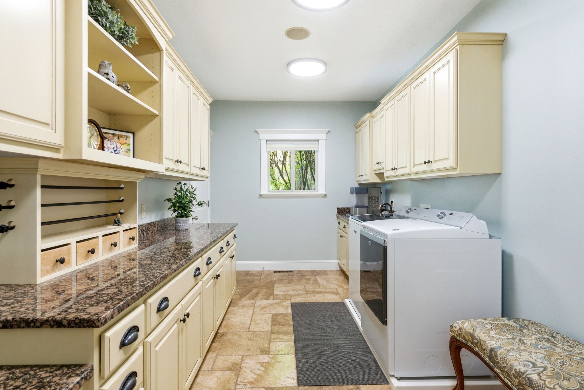 Laundry room with cabinet space, independent washer and dryer, and light stone finish floors