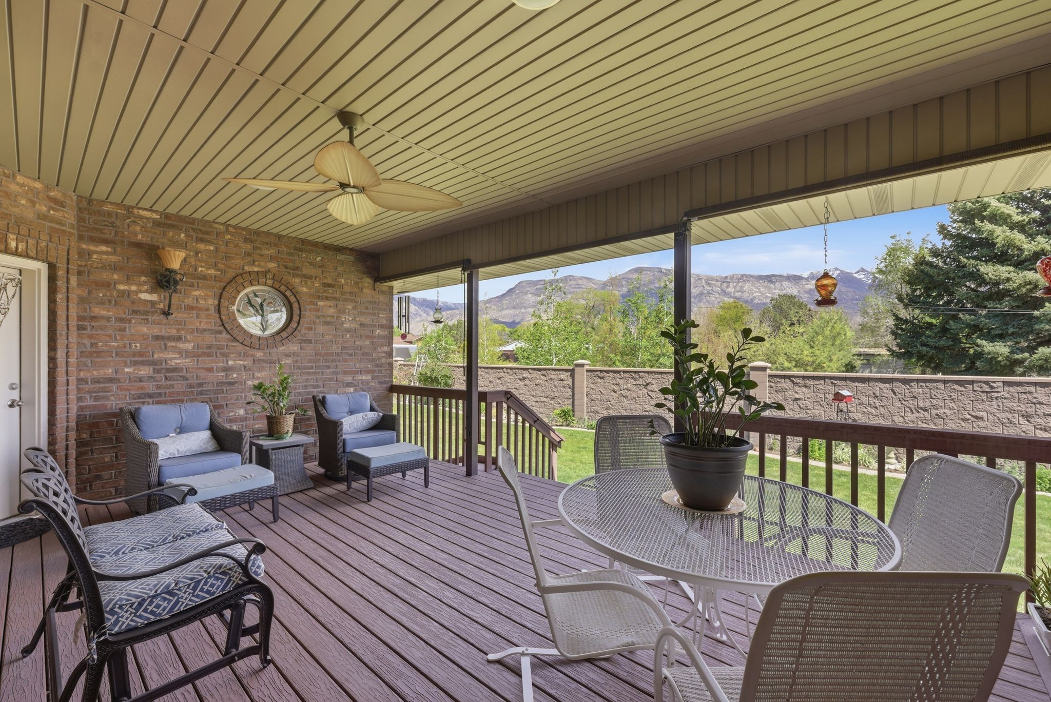 Sunroom with a ceiling fan, an outdoor living / dining area, and a deck with mountain view