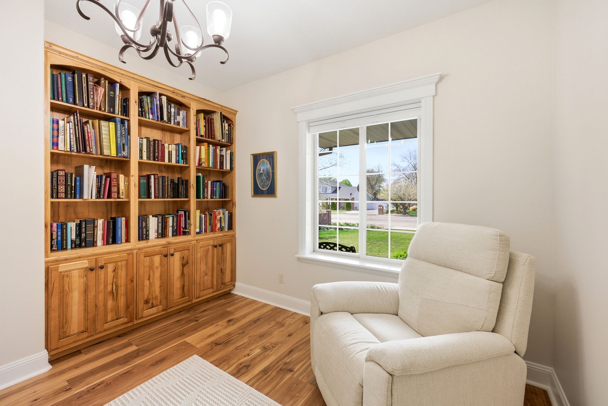 Living area featuring light wood-style floors and suspended lighting