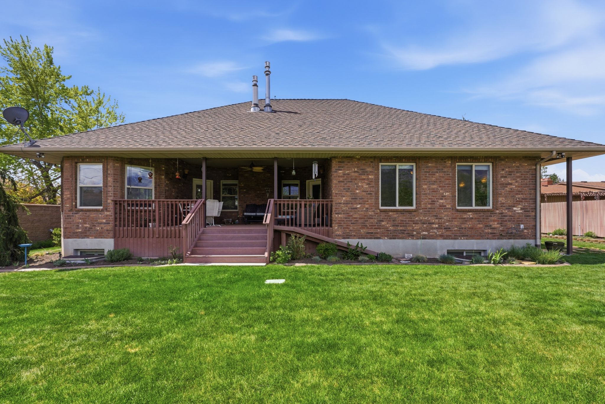 Rear view of property with a ceiling fan, brick siding, roof with shingles, and a porch