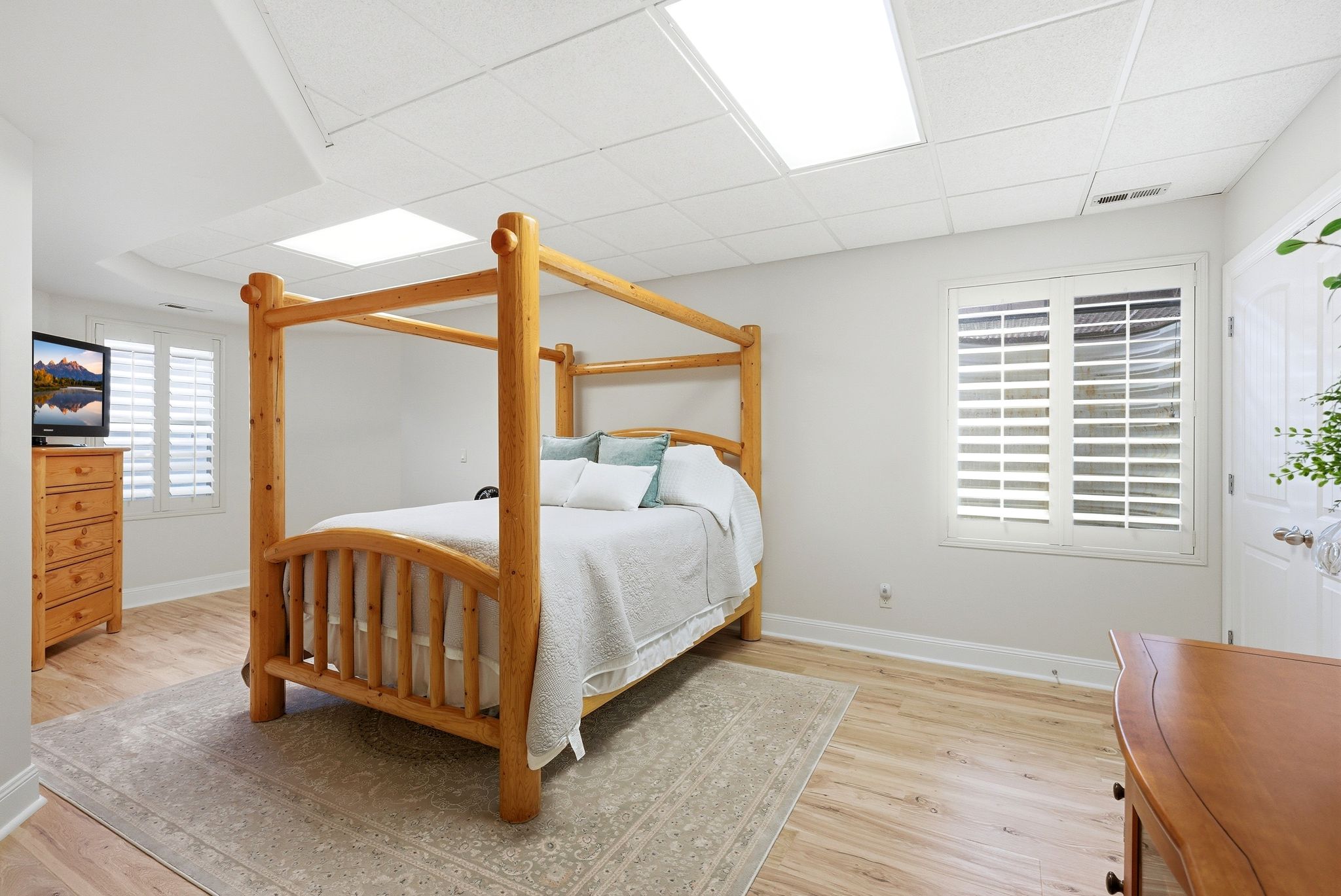 Bedroom with a paneled ceiling and light wood-style floors