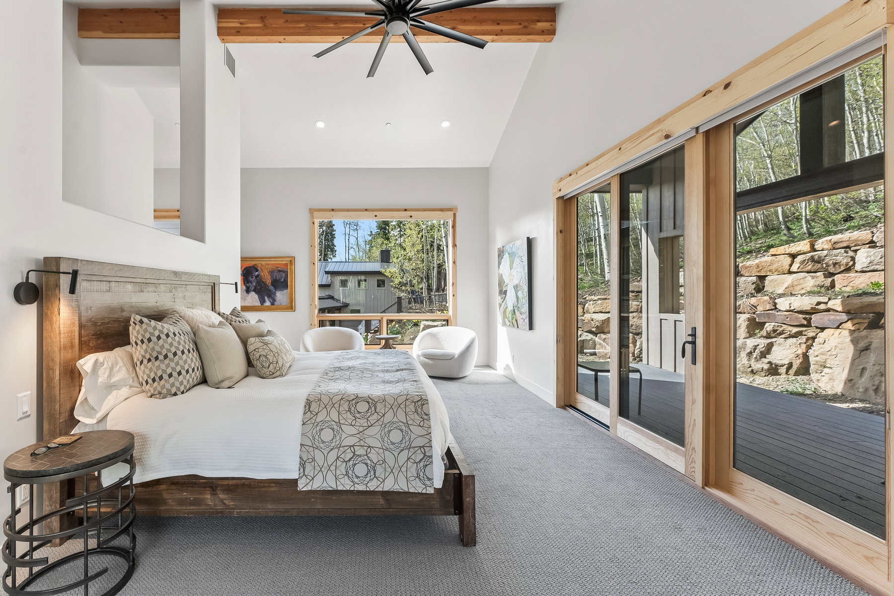 Bedroom with vaulted ceilings, exposed wood beams, and a ceiling fan