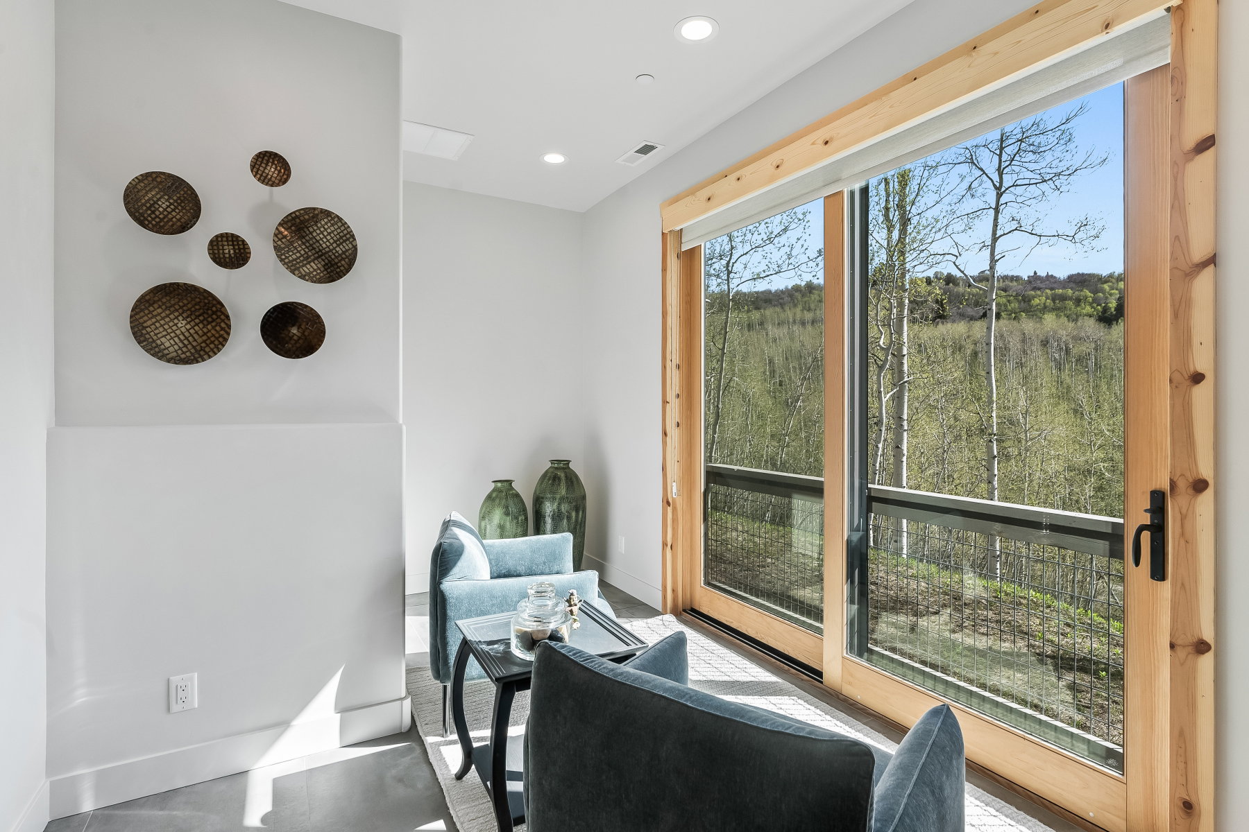 Expansive sliding glass doors with natural wood frames, offering abundant natural light and a broad outdoor perspective
