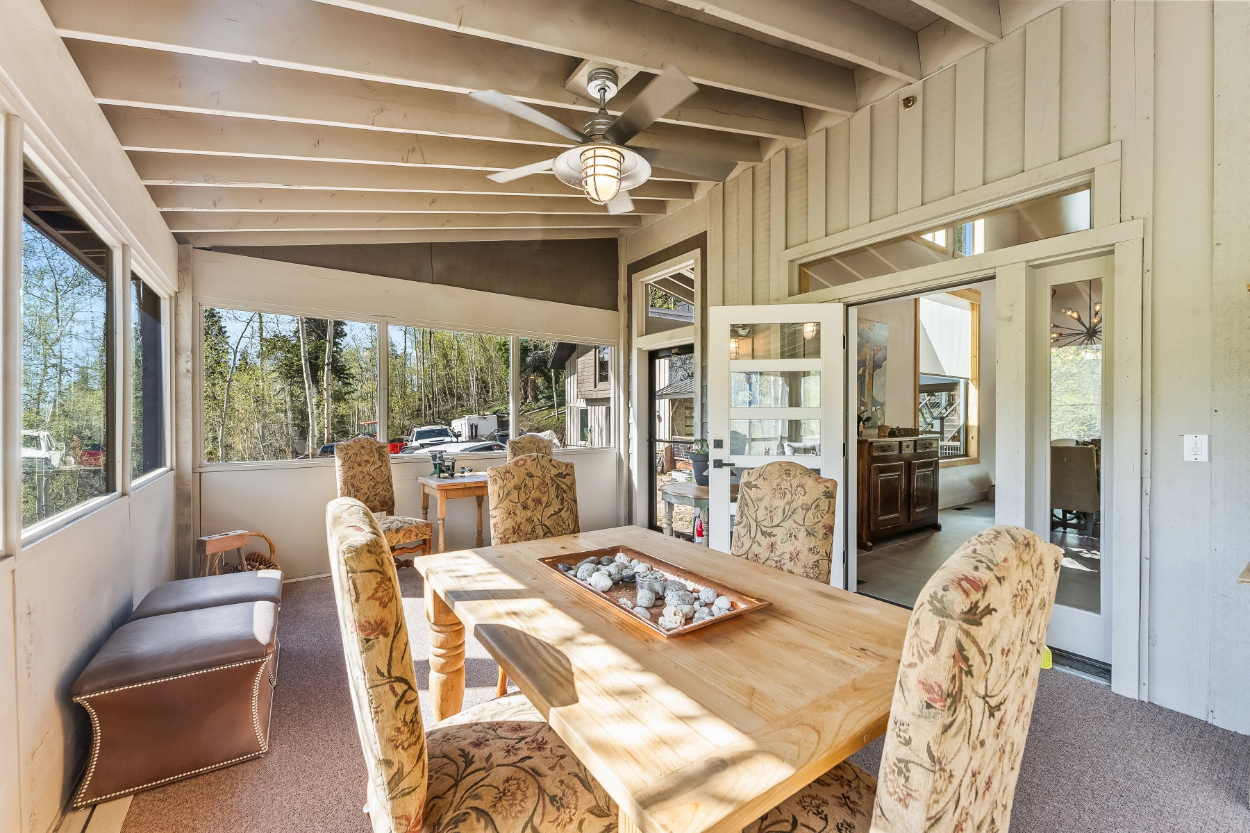 Enclosed porch featuring exposed beam ceiling, ceiling fan, and carpeted flooring