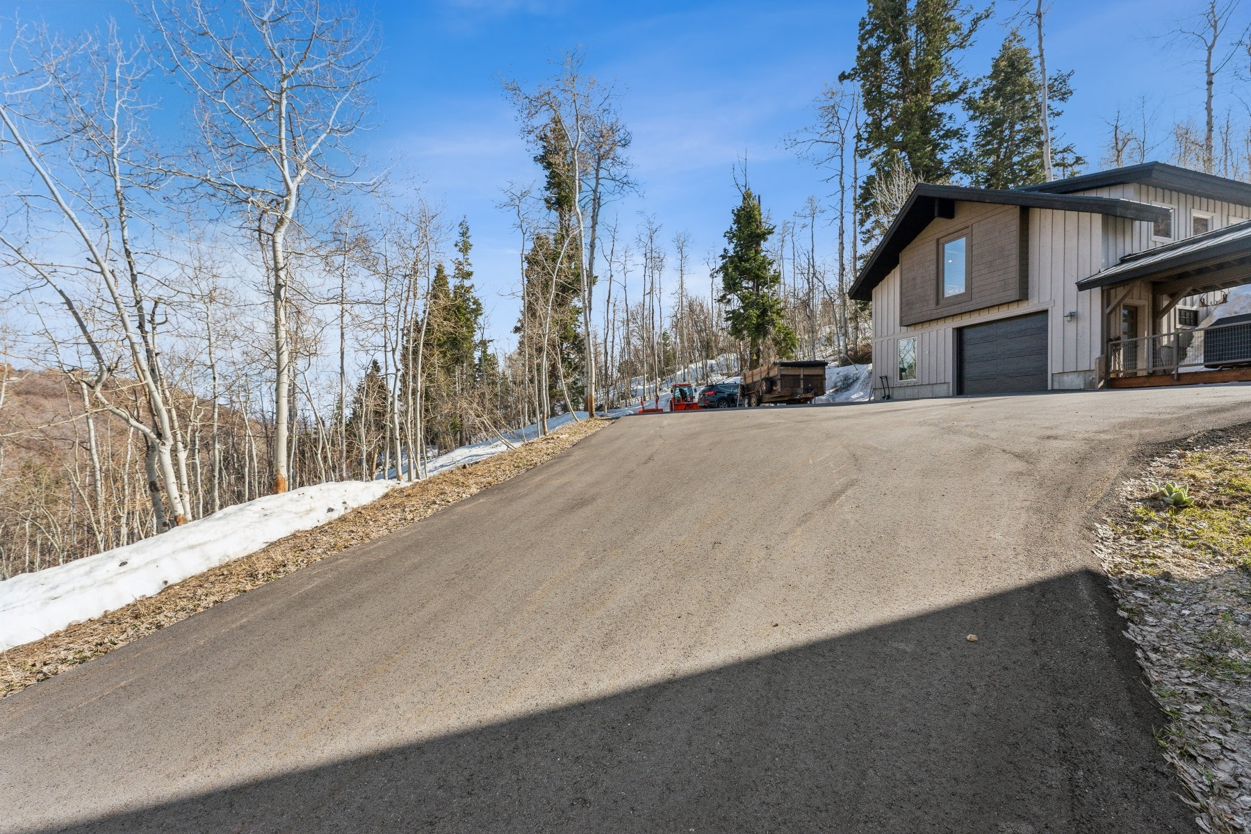 Asphalt driveway leading to a modern home with a two-car garage