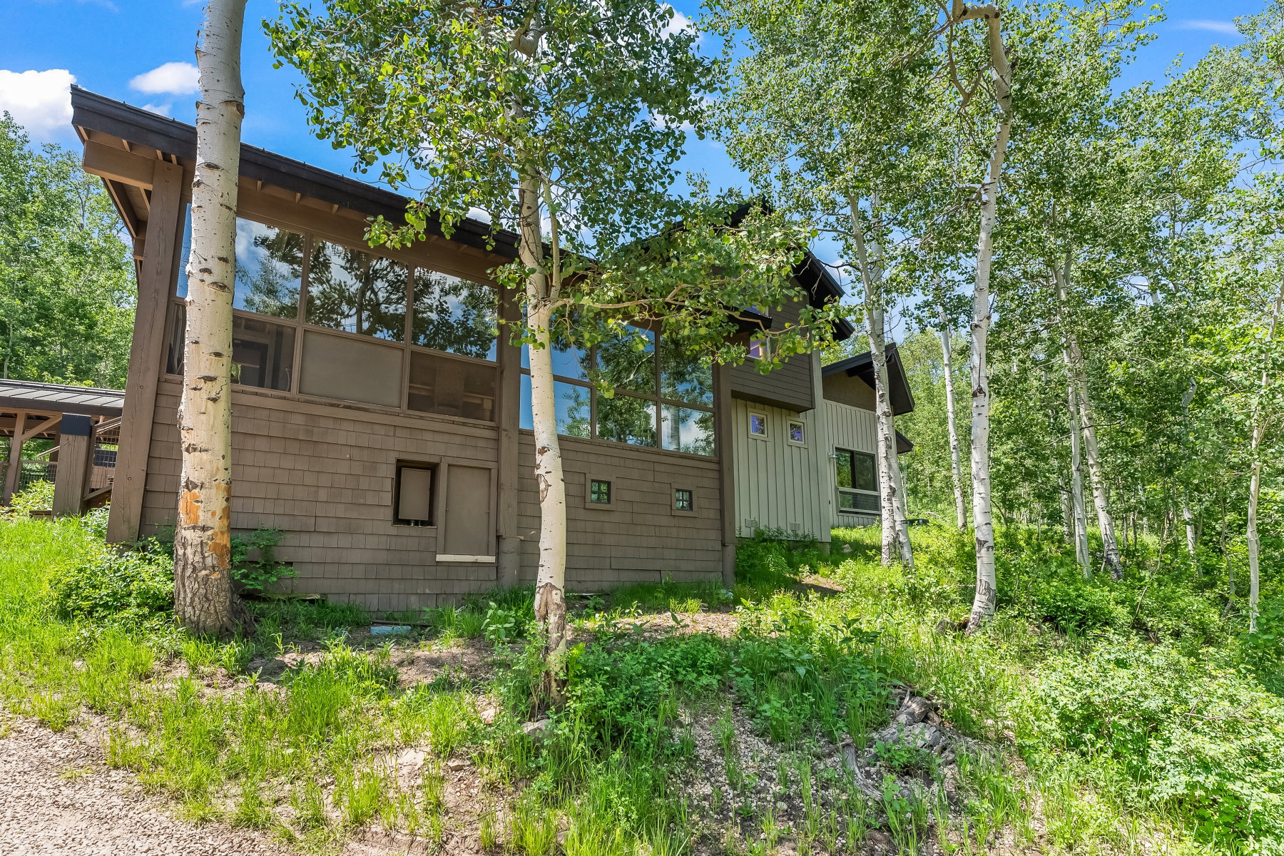 Contemporary exterior with expansive floor-to-ceiling windows, wood shake siding, and a sloped roofline