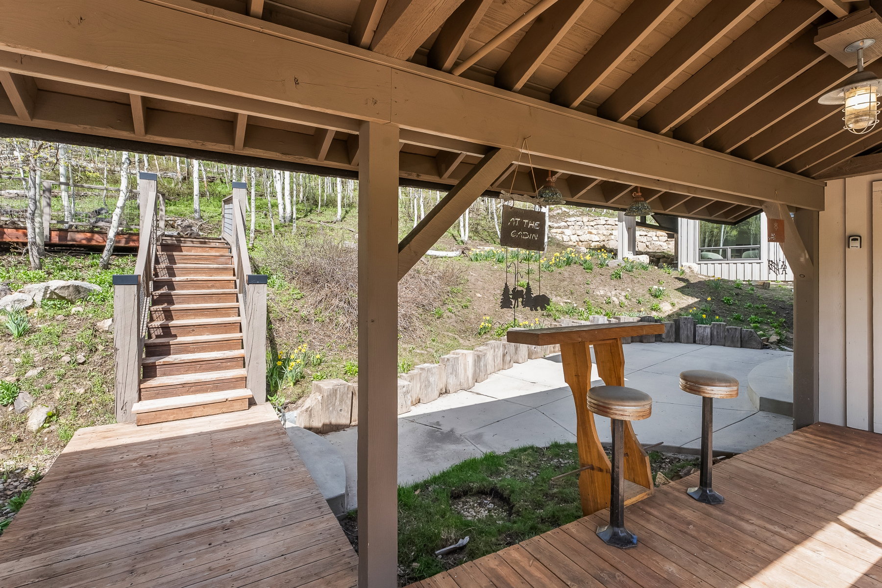 Covered patio featuring wood-finish flooring, exposed beam ceiling, and a built-in bar