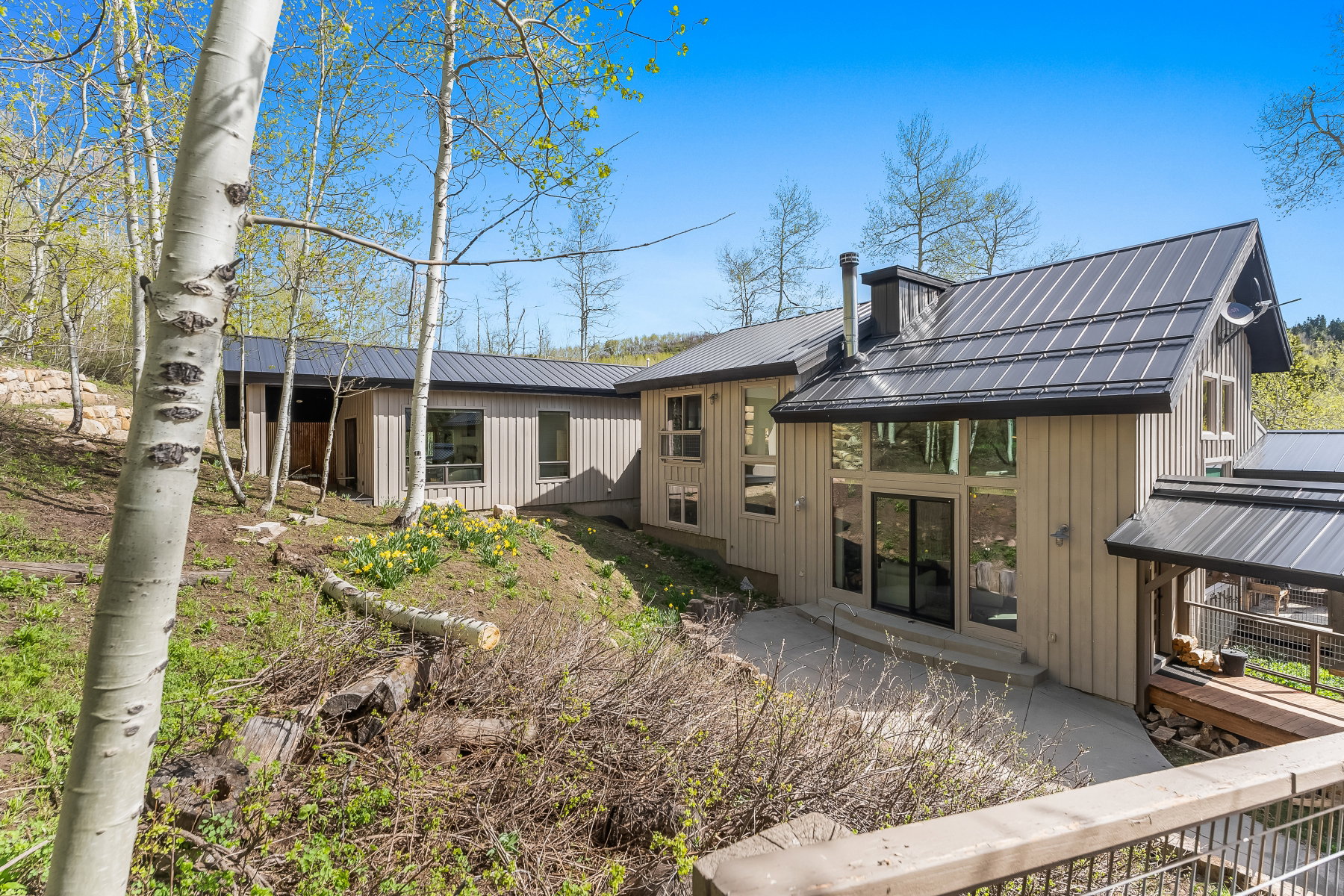 Contemporary exterior featuring vertical siding and a dark metal roof