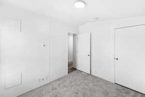 Carpeted room with a flush-mount ceiling light