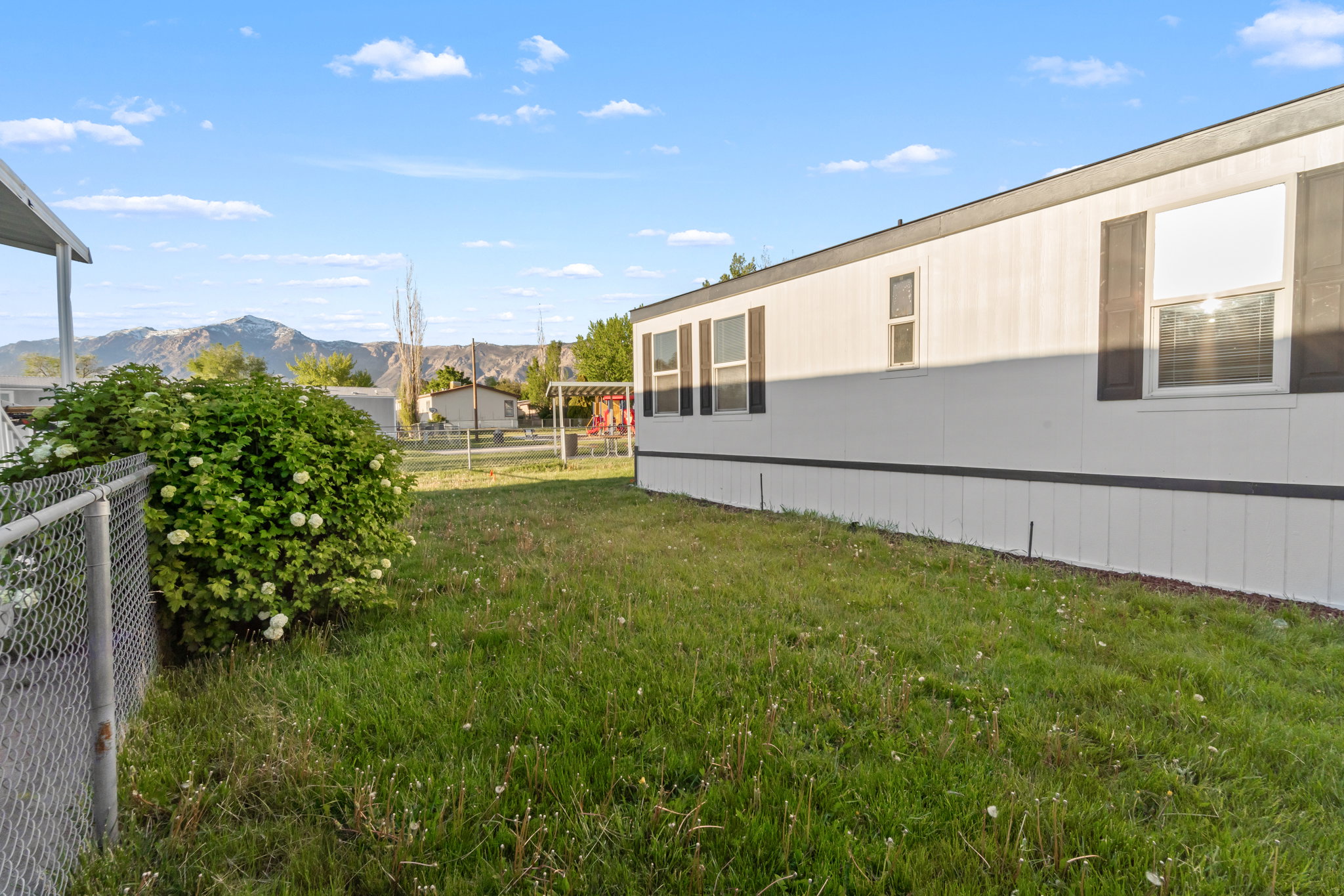 Side exterior with white siding and dark shutters