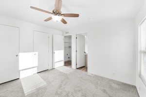 Carpeted bedroom with a wood-finish ceiling fan and light fixture