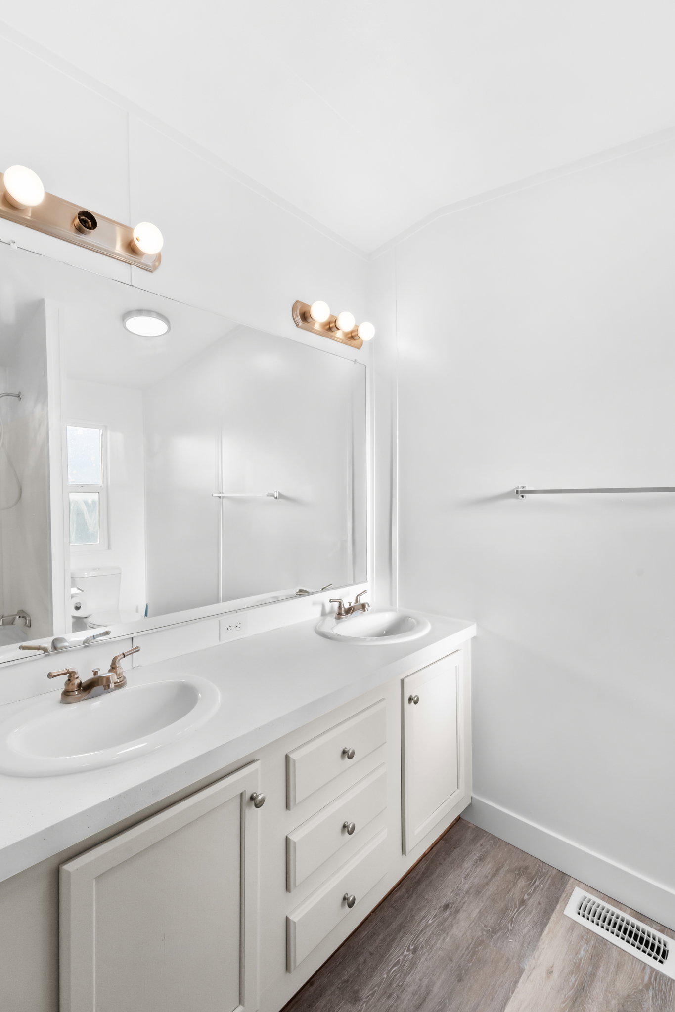 Double vanity featuring white cabinetry and integrated sinks with brushed nickel faucets