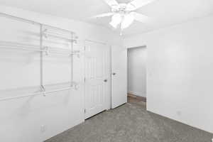 Bright interior room featuring white walls and a gray carpeted floor