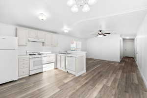 Kitchen featuring white cabinetry, white appliances, laminate countertops, and wood-finish flooring