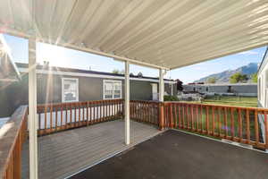 Covered outdoor deck featuring wood-finish flooring and a wood railing system