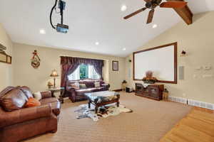 Spacious room featuring a vaulted ceiling with exposed wood beam, recessed lighting, and a ceiling fan