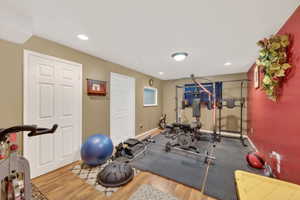 Versatile multi-purpose room featuring wood-finish flooring, recessed lighting, and a window
