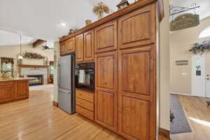 Kitchen featuring extensive wood cabinetry, stainless steel refrigerator, and built-in oven