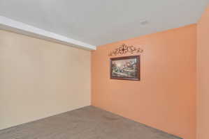 Carpeted room with two-tone wall paint and a textured ceiling
