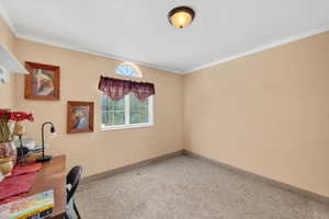 Carpeted room featuring a window with white blinds and an arched transom window above