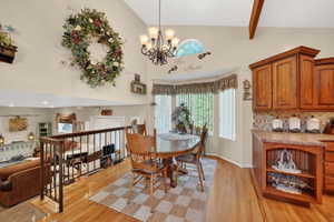 Formal dining area featuring a bay window, hardwood flooring, and a decorative chandelier