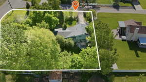 Spacious property featuring a large home with a light green exterior, a dark grey roof, and a paved patio area