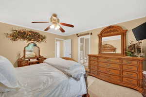 Carpeted bedroom with neutral wall tones and crown molding