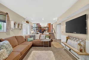 Entertainment area featuring recessed lighting, a large wall-mounted television, and wainscoting