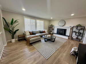 Staged Living area featuring wood-finish flooring, recessed lighting, and a fireplace with a mantel and hearth