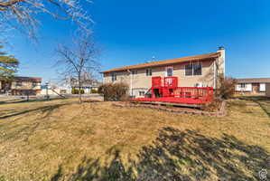 Back of property with a wooden deck and a chimney
