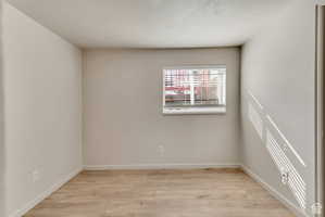 Spare room with light wood-type flooring and baseboards