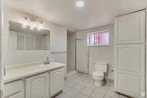 Bathroom featuring vanity, a stall shower, light tile patterned floors, and a closet