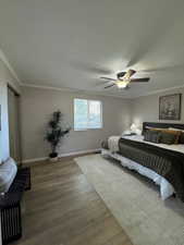 Staged Spacious room featuring wood-finish flooring, a ceiling fan with integrated lighting, and a window with blinds