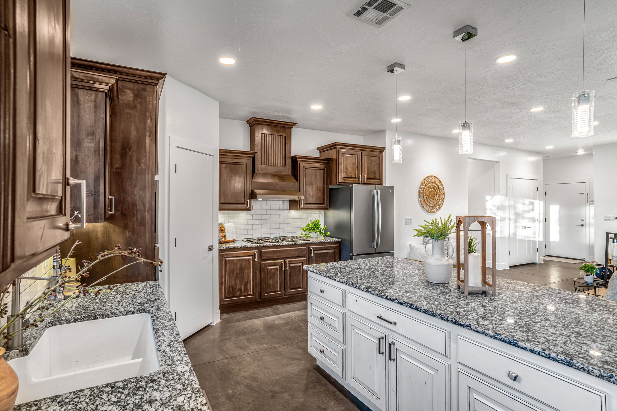 Kitchen featuring an expansive island with white cabinetry and a speckled countertop