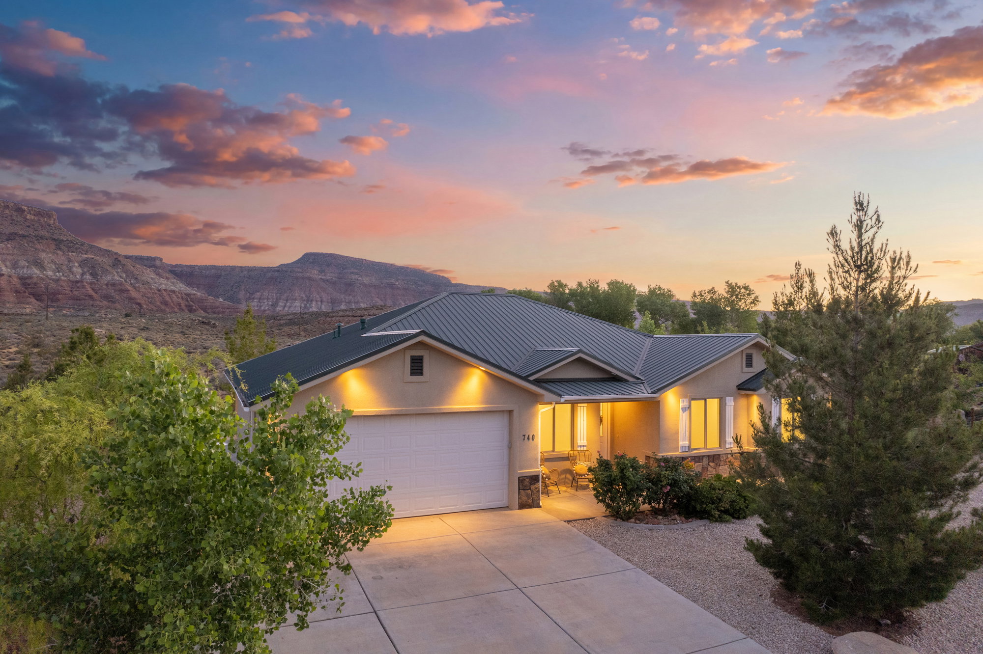 Single-story residence featuring a metal roof, stucco exterior, and stone accents