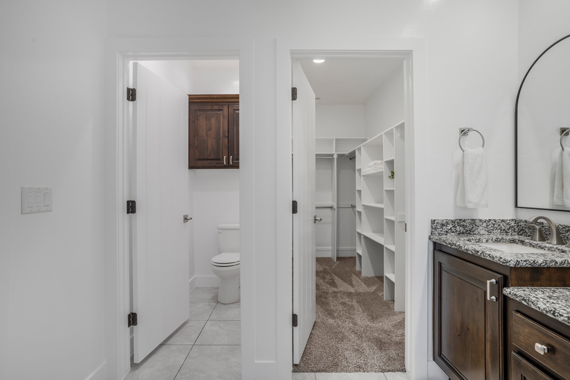 Bathroom vanity featuring a granite countertop, undermount sink, and dark wood cabinetry
