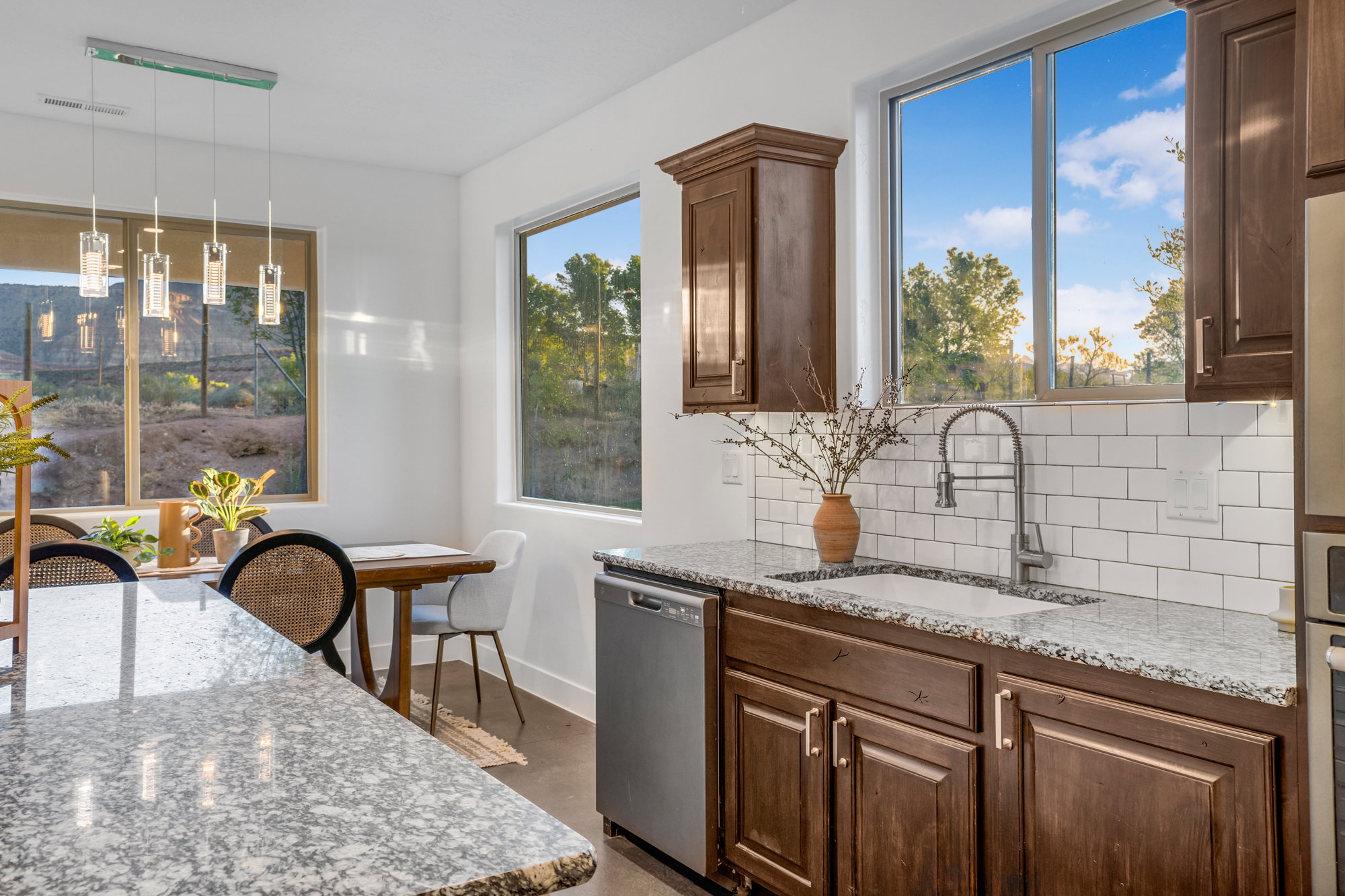 Kitchen featuring granite countertops, a white subway tile backsplash, stainless steel appliances, and dark wood cabinetry