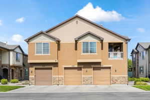 Multi-story residential building with stucco and stone veneer facade