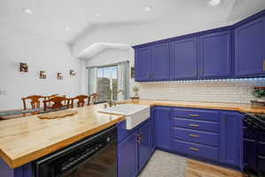 Updated kitchen with butcher block countertops, subway tile backsplash, farmhouse sink, modern lighting