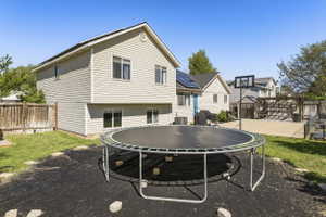 Backyard featuring a concrete patio, a wooden pergola, and a basketball hoop