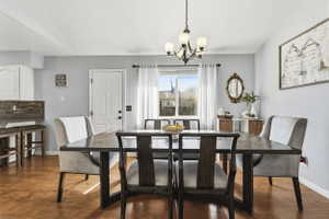 Dining area featuring wood-finish flooring and a multi-arm chandelier